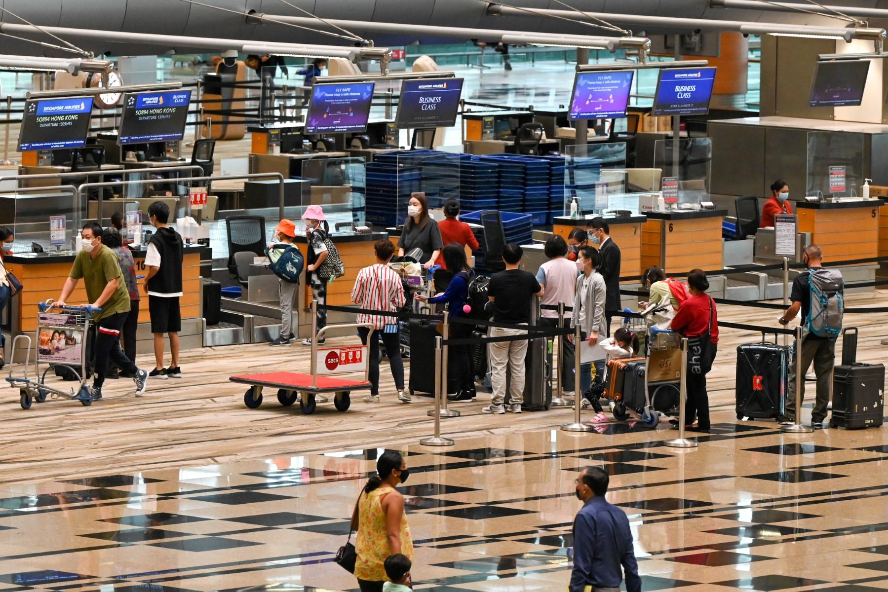 Travellers check in for their flight at the Singapore Airlines counter in the departure hall at Changi International Airport in Singapore on Dec 2. Photo: AFP