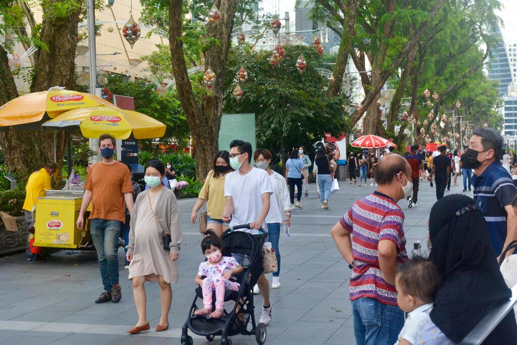 People wearing protective face masks walk along the Orchard Road shopping area in Singapore on Nov 28. Photo: AP