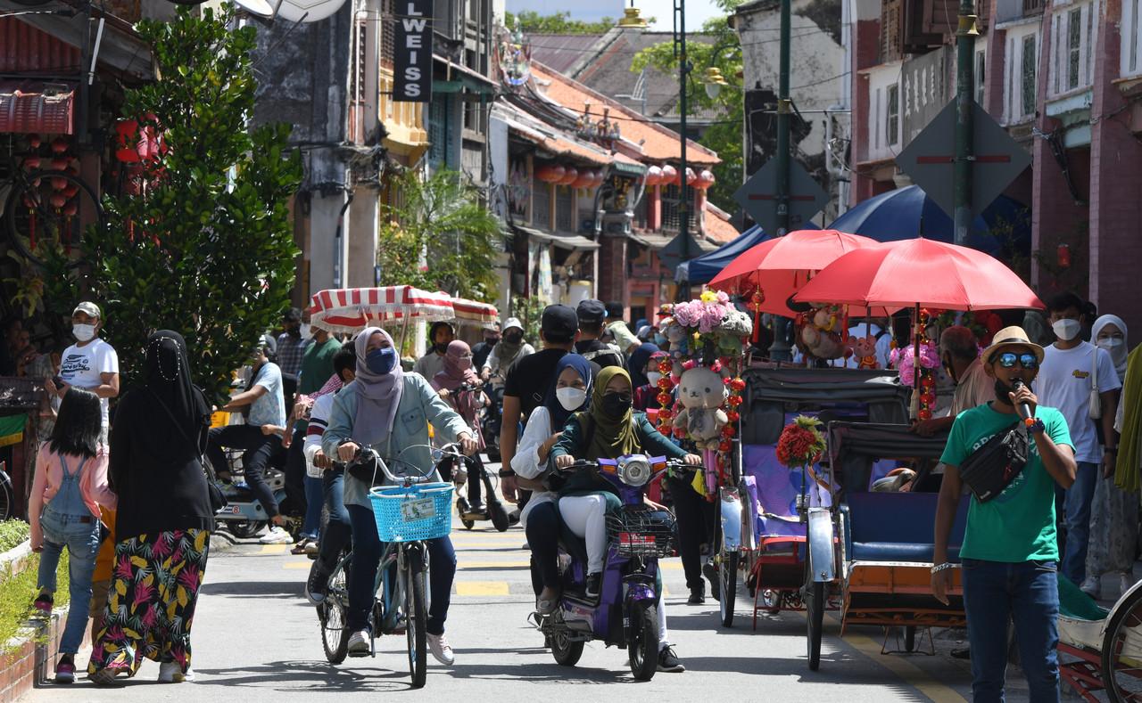 Tourists mingle with locals at Lebuh Armenian in George Town, Penang, as the end-year school holidays begin. Photo: Bernama