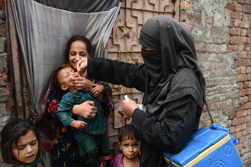 A health worker administers polio vaccine drops to a child during a polio vaccination campaign at a slum area in Lahore on Aug 2. Photo: AFP