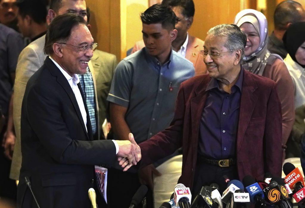 Bekas perdana menteri Dr Mahathir Mohamad bersalaman dengan Anwar Ibrahim dalam gambar fail 22 Februari 2020. Gambar: AP