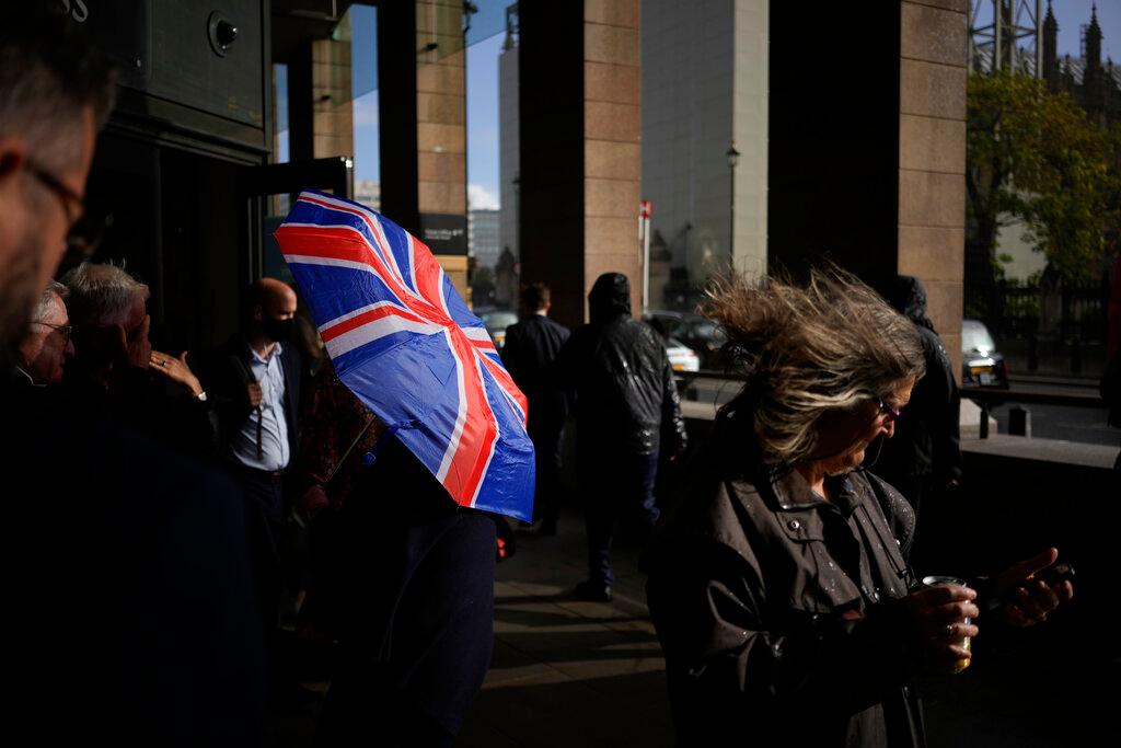 A person holds a British Union flag design umbrella as a gust of wind blows during a rain shower in the Westminster area of London, Oct 20. Photo: AP
