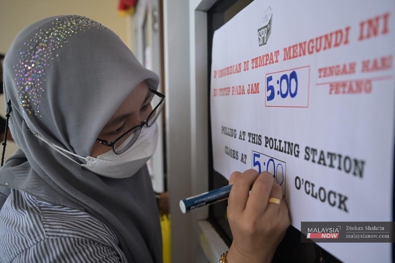 Petugas SPR menyiapkan papan tanda di pusat pengundian bagi PRN Sarawak pagi ini.