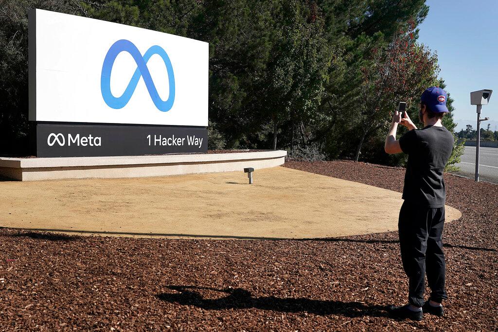 A Facebook employee takes a photo in front of the new Meta Platforms Inc sign outside the company headquarters in Menlo Park, California, Oct 28. Photo: AP
