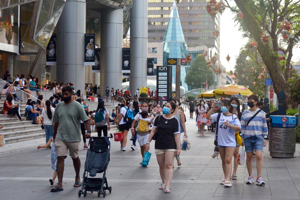 People wearing protective face masks walk along the Orchard Road shopping area in Singapore on Nov 28. Photo: AP
