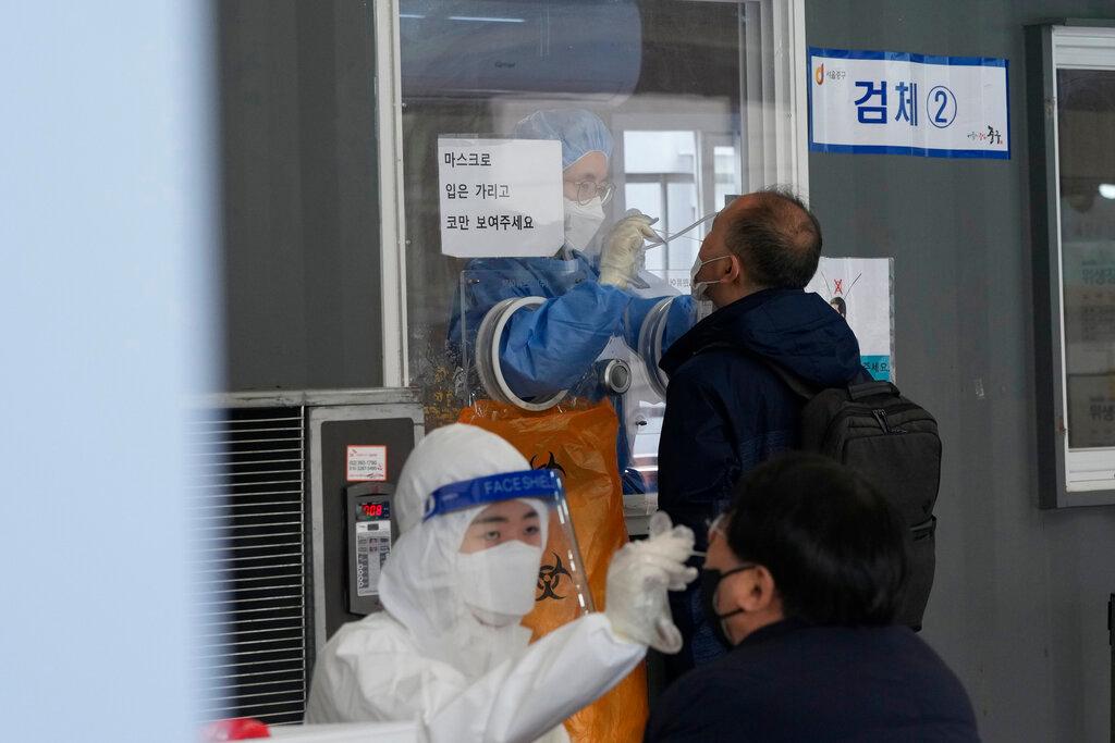 Medical workers take nasal samples from people at a makeshift coronavirus testing site in Seoul, South Korea, Dec 14. Photo: AP