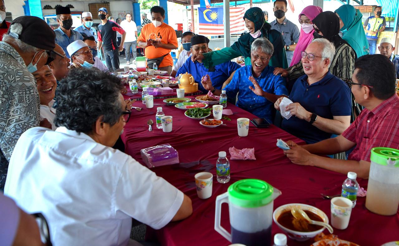 Former prime minister Najib Razak (seated, second right) shares a meal with locals during the campaign period for the Melaka election at the Kampung Hailam jetty, Oct 30. Photo: Bernama
