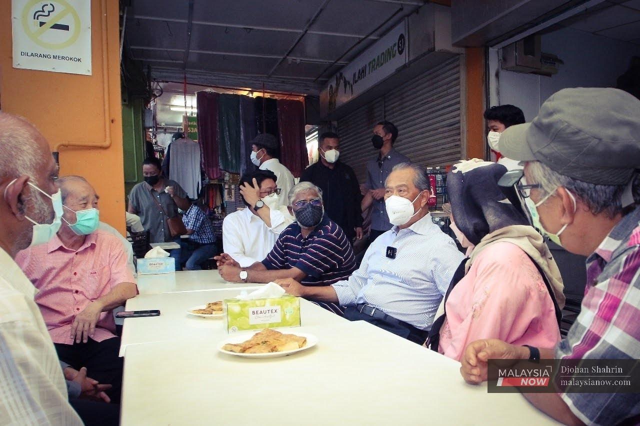 Pengerusi Majlis Pemulihan Negara, Muhyiddin Yassin bertanya sesuatu kepada ahli persatuan peniaga di sekitar Kuching semasa mengadakan lawatan ke Lebuh India, Sarawak.