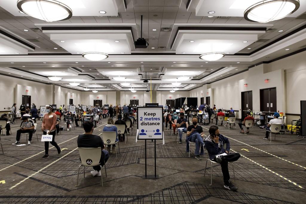 People wait in rows for their Covid-19 vaccine inside the International Conference Centre in Mississauga, Ontario, Canada, on May 15. Photo: AFP