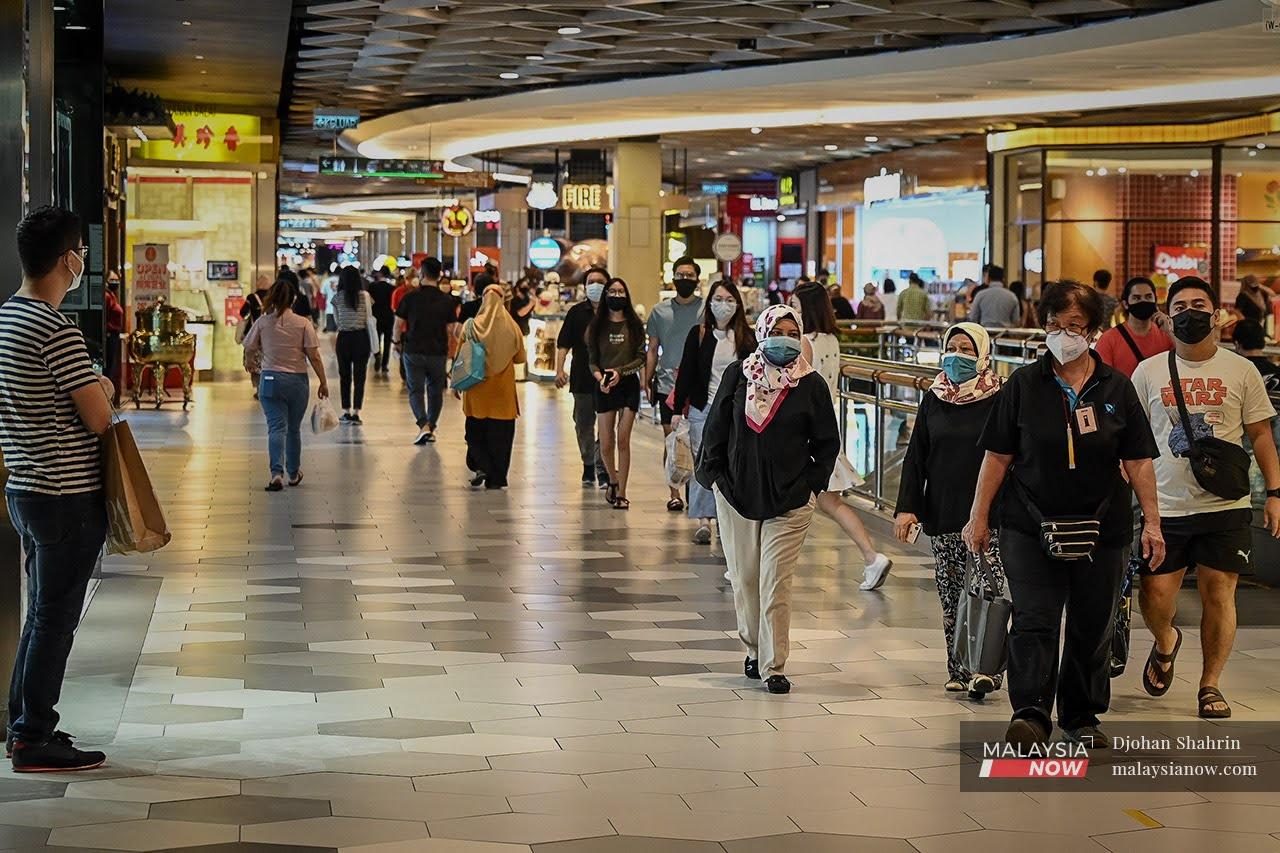 Shoppers wearing face masks stroll through a mall in Kuala Lumpur.