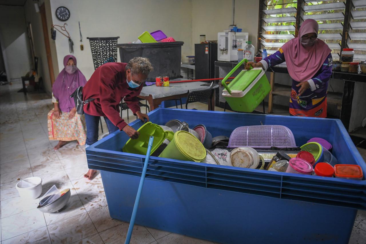 A family at Kampung Pasir Raja in Dungun, Terengganu, clean up their house which was flooded after heavy rain yesterday. Photo: Bernama
