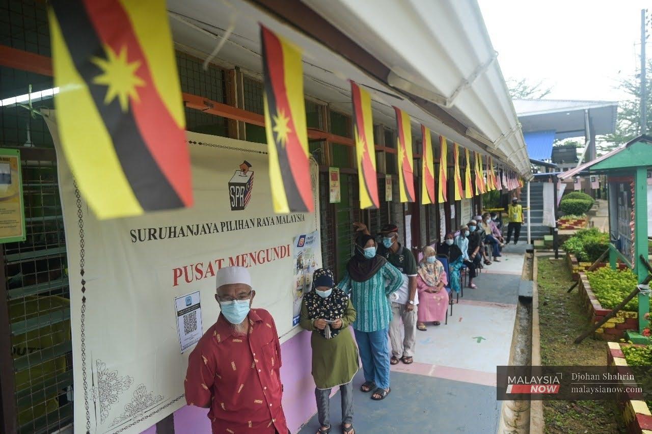 Voters queue outside the polling centre at SK Pulau Salak for the Sarawak election today.