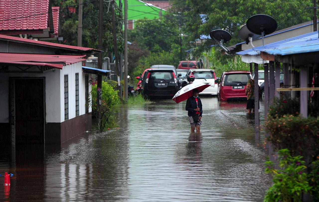 A villager wades through flood water at Kampung Johan Setia in Klang. Photo: Bernama