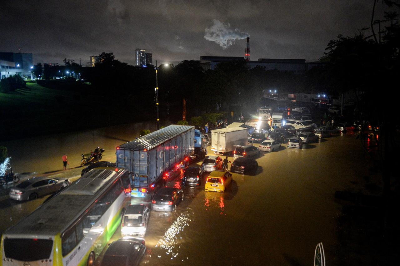 Vehicles are stranded at a road in Section 21, Shah Alam, early this morning following continuous heavy rain throughout the Klang Valley. Photo: Bernama