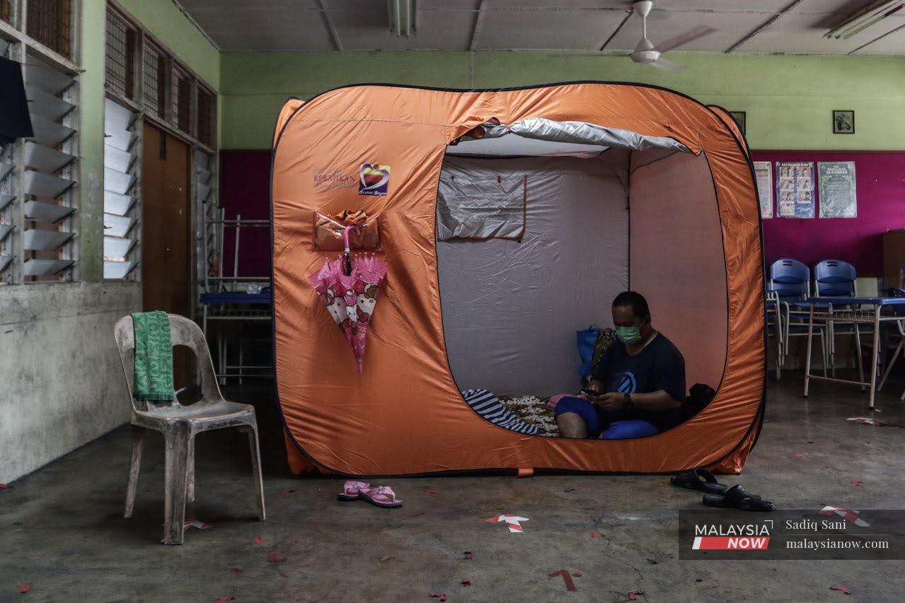 A man sits in a tent at a flood relief centre in Klang.