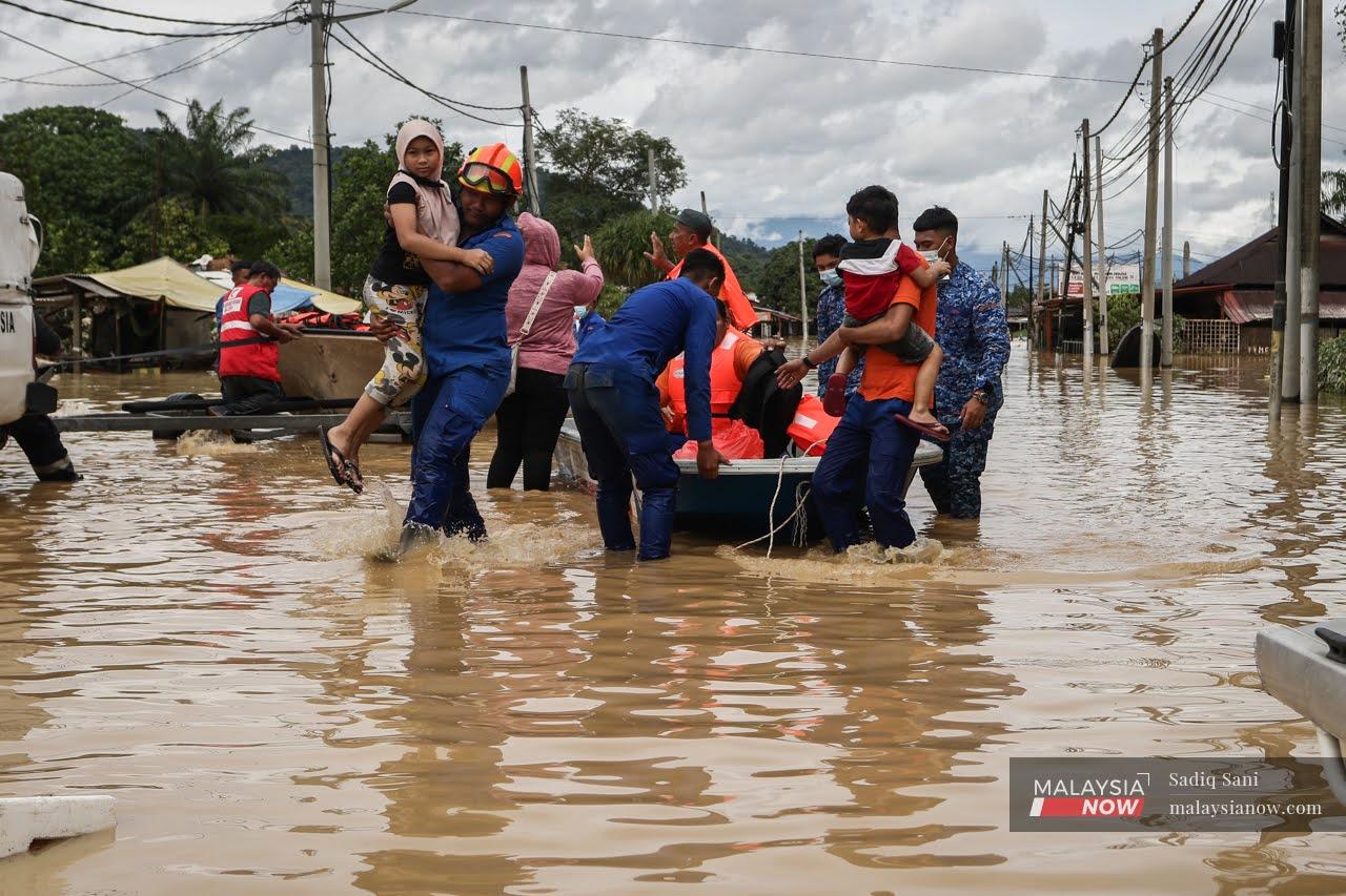 Mangsa banjir di Kampung Sungai Serai, Klang diselamatkan orang ramai dan pasukan penyelamat untuk dipindahkan ke PPS.