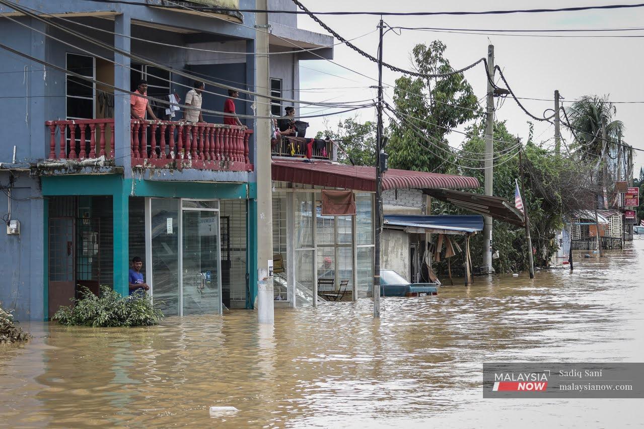 Penduduk tempatan duduk di tingkat atas bagi menyelamatkan diri daripada banjir Kampung Sungai Serai, Hulu Langat.