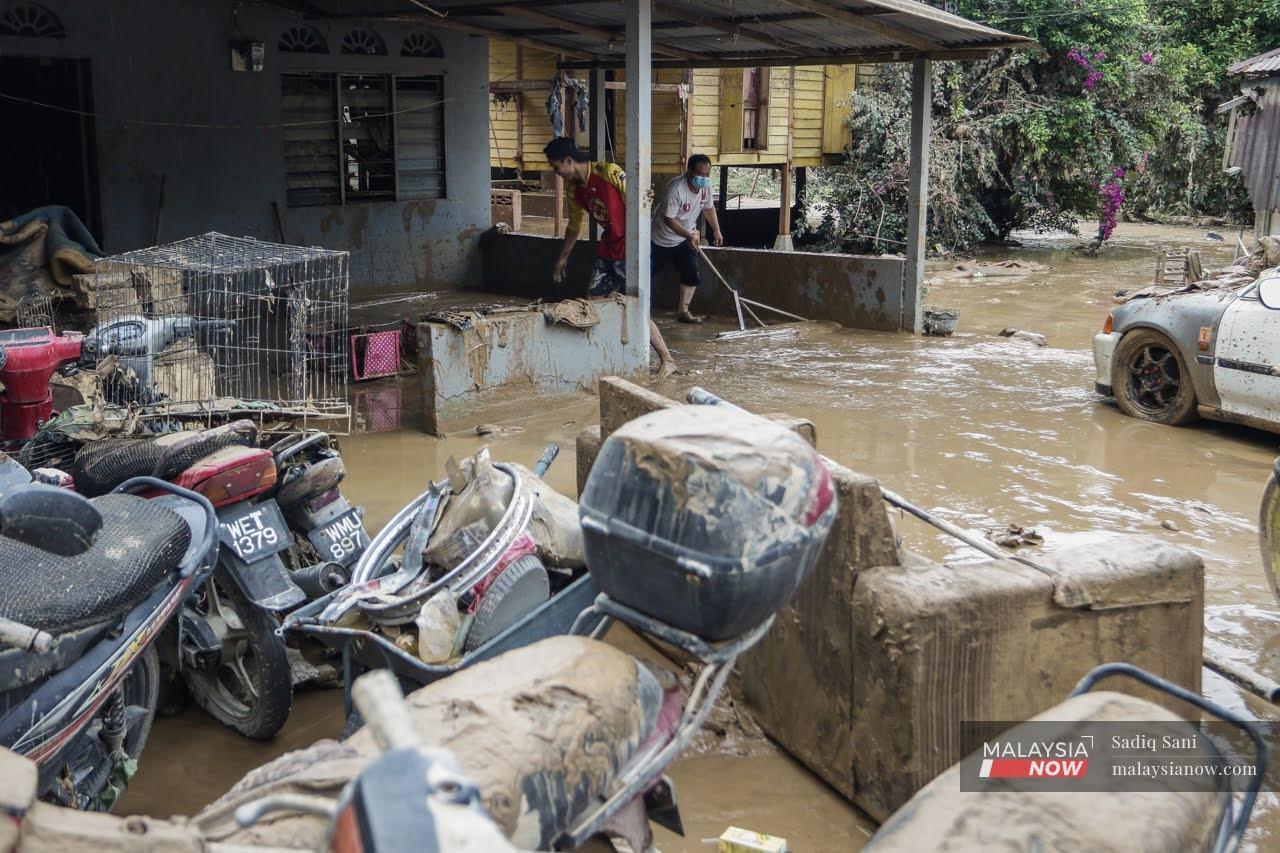 Mangsa banjir mula membersihkan kawasan rumah mereka yang dimasuki air akibat banjir kilat yang melanda Selangor hujung minggu lalu di Kampung Masjid, Hulu Langat.