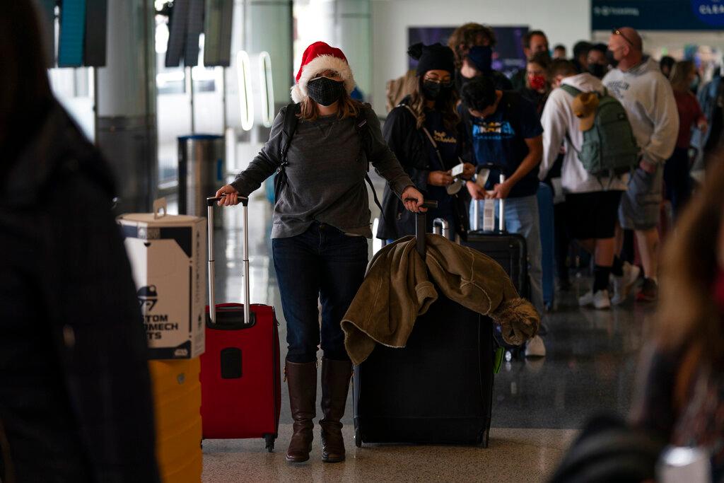 A woman waits in line to check in for her flight at the Los Angeles International Airport in Los Angeles, Dec 20. Photo: AP