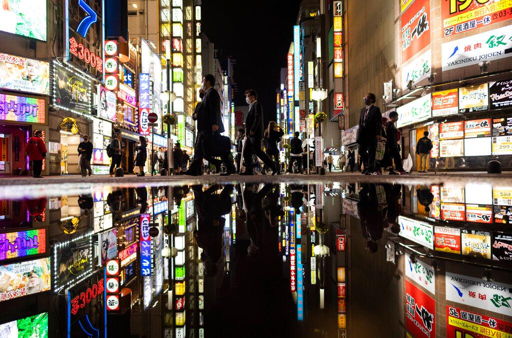 People walk through the famed Kabukicho entertainment district of Tokyo on the first night of the government's lifting of a coronavirus state of emergency, Oct 1. Photo: AP