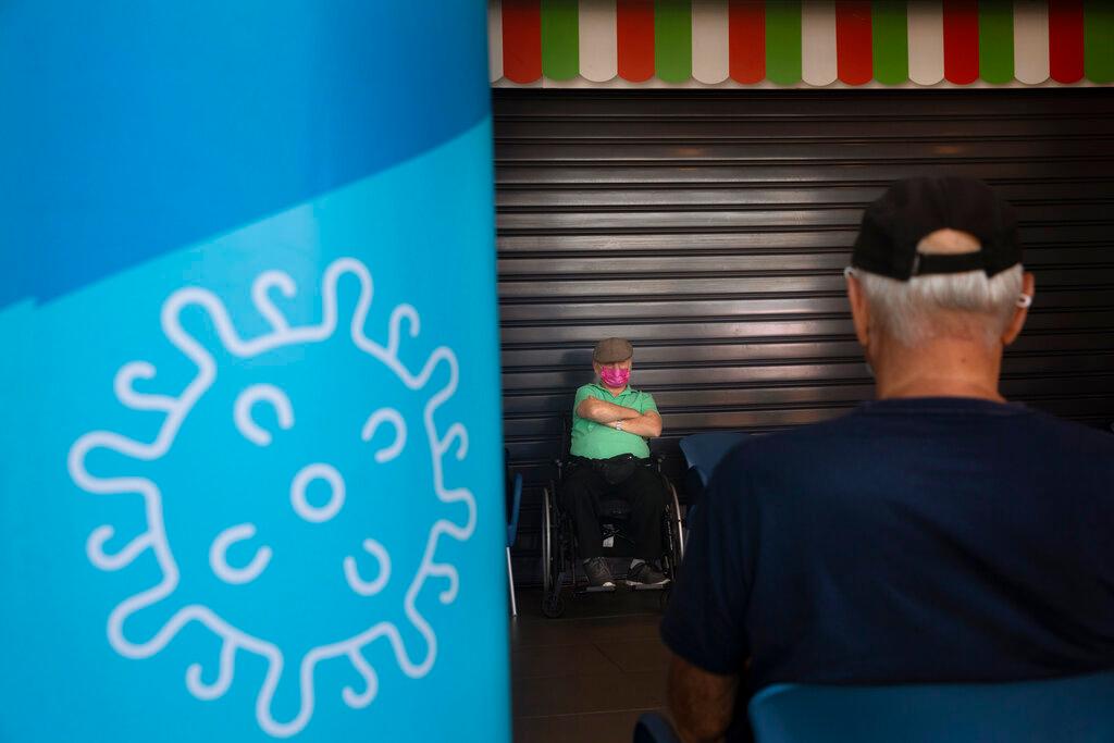 Men are seated after receiving a third dose of Pfizer-BioNTech Covid-19 vaccine at a coronavirus vaccination centre in Tel Aviv, Israel, Aug 10. Photo: AP