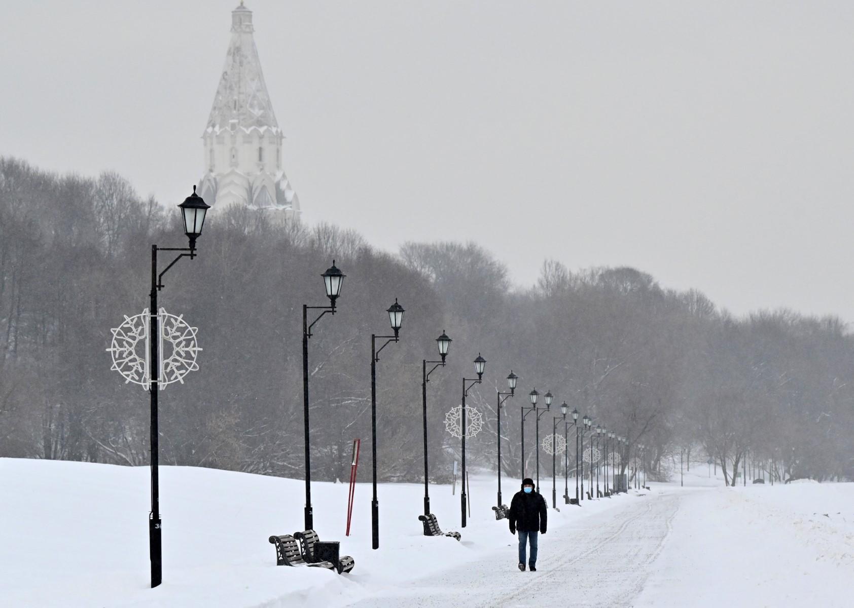 A man wearing a face mask walks in the snow at the Kolomenskoye Park, in Moscow on Dec 21. Photo: AFP