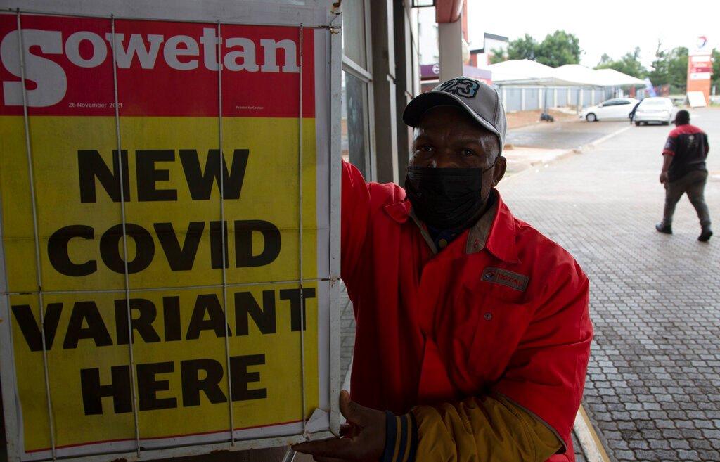 A petrol attendant stands next to a newspaper headline in Pretoria, South Africa, Nov 27. Photo: AP