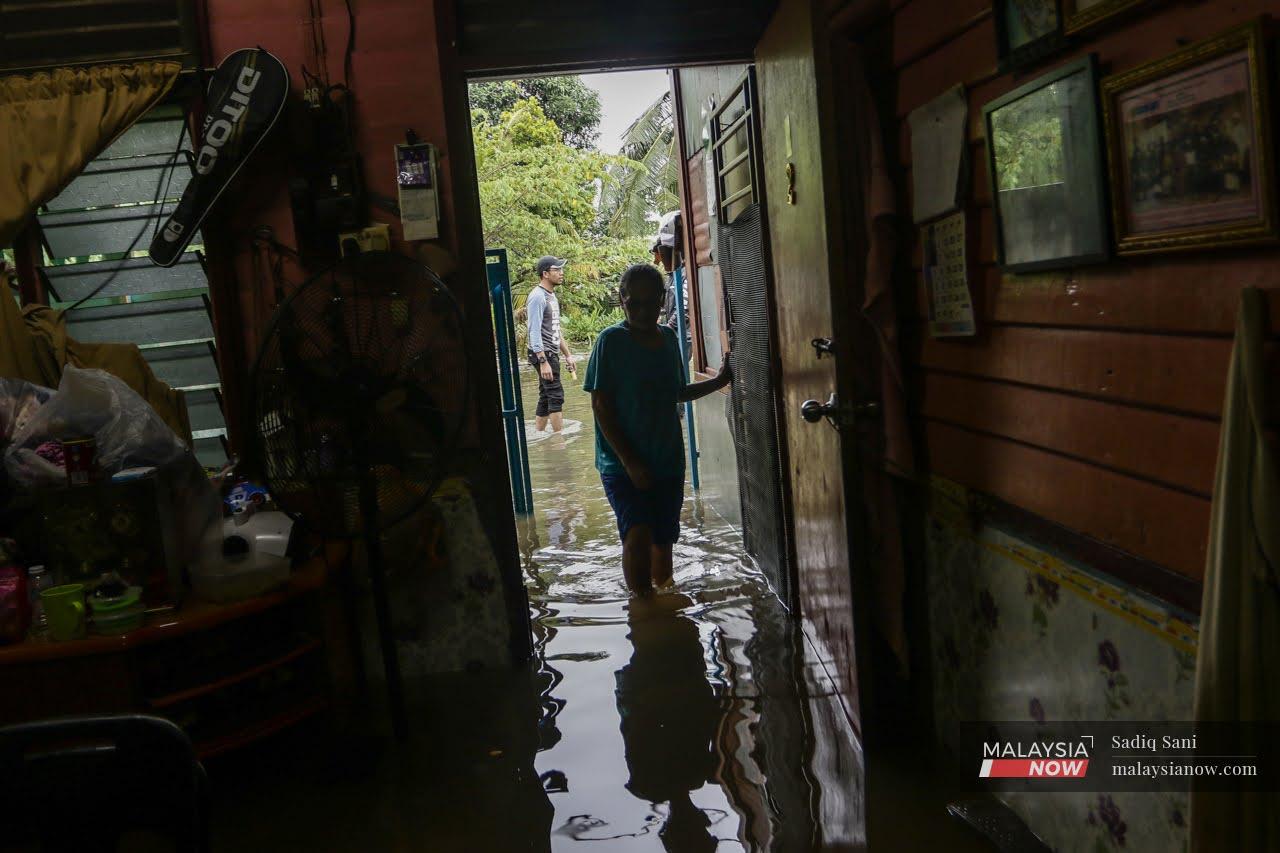 Seorang wanita memeriksa rumahnya yang digenangi air di Kampung Delek, Klang. Selangor menjadi negeri yang paling teruk terjejas akibat banjir hujung minggu lalu.