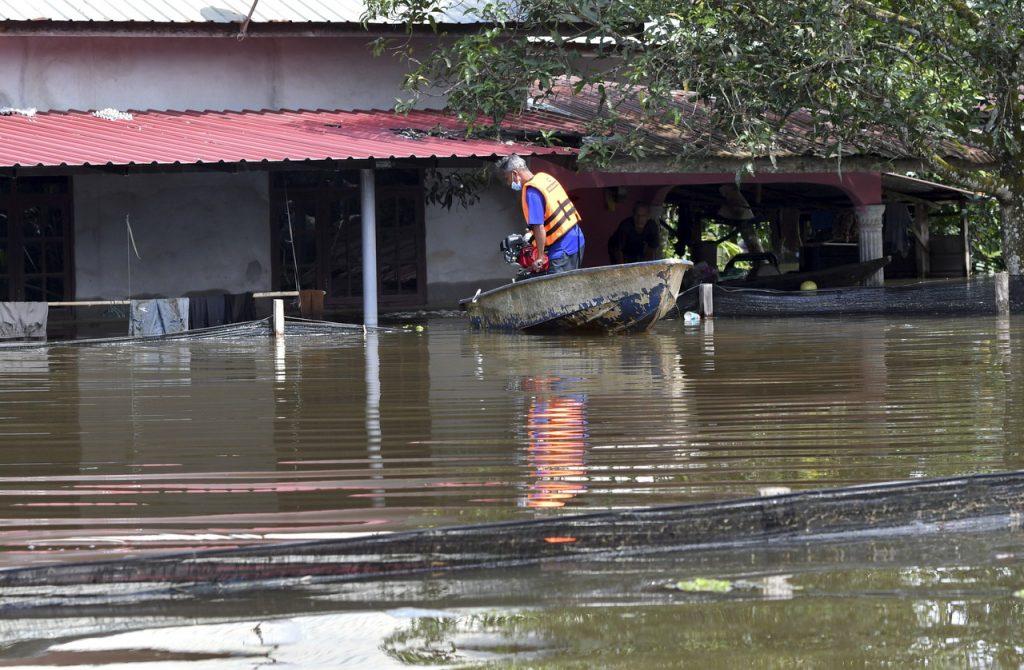 Seorang lelaki memeriksa rumahnya yang digenangi air banjir di Kampung Padang Licin, Pasir Mas, Kelantan. Gambar: Bernama