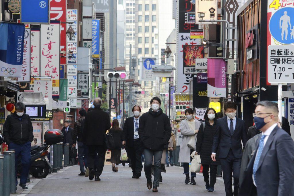 People wearing face masks to protect against the spread of the coronavirus walk on a street in Tokyo, Jan 27. Photo: AP