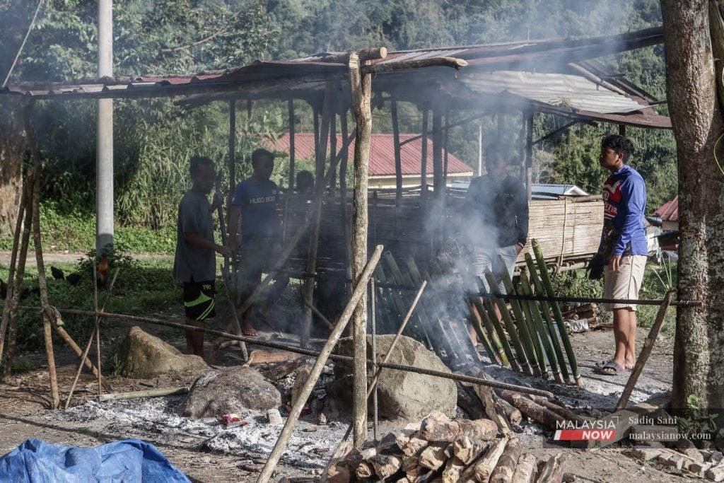 Sekumpulan anak muda Orang Asli Semai menjaga api lemang yang akan menjadi juadah Krismas di Kampung Pos Slim, Perak.