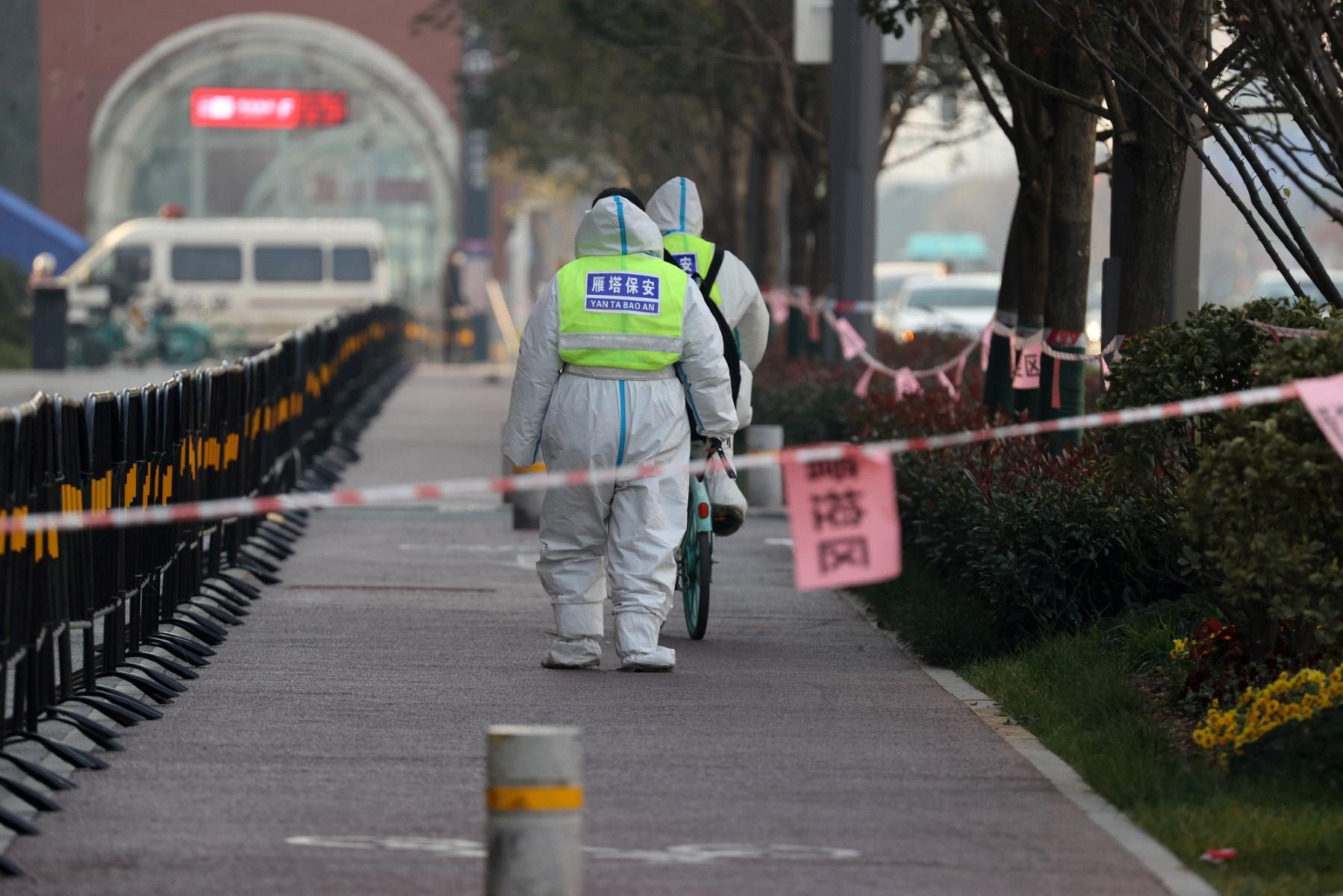 This photo taken on Dec 22 shows security guards walking in an area under restrictions following a recent Covid-19 outbreak in Xi'an in China's northern Shaanxi province. Photo: AFP