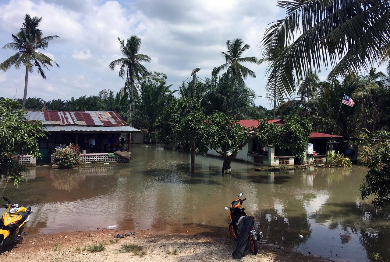 Homes in a neighbourhood in Sungai Rambai, Jasin, remain surrounded by stagnant floodwater, Dec 28. Photo: Bernama