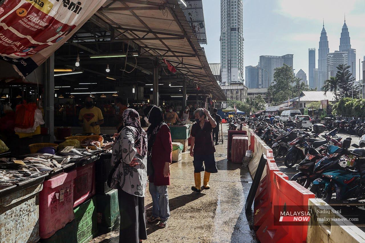 Customers stop to buy fresh produce at the morning market in Jalan Raja Bot, Kuala Lumpur.