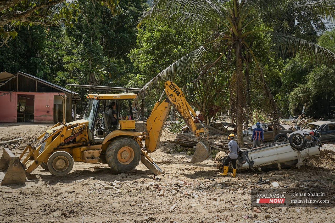 Pekerja kontraktor lantikan melakukan kerja-kerja pembersihan di kawasan banjir yang memusnahkan beberapa harta benda awam dan kediaman di Jalan Sungai Lui, Hulu Langat.