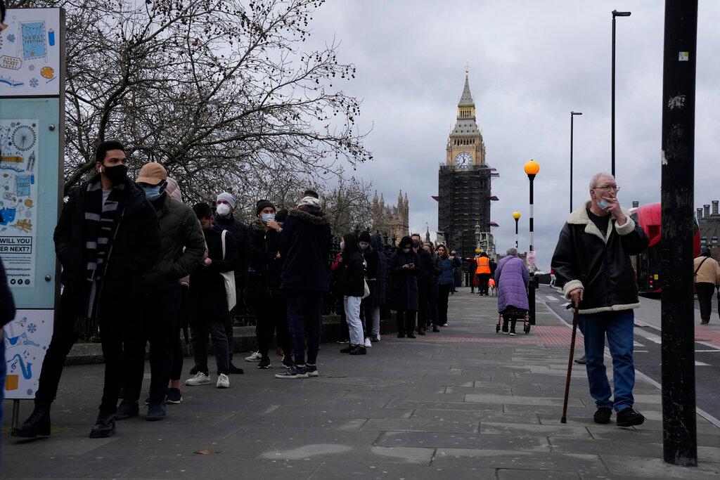 People queue to go for Covid-19 booster jabs at St Thomas' Hospital, backdropped by the scaffolded Elizabeth Tower, known as Big Ben, and the Houses of Parliament, in London, Dec 13. Photo: AP