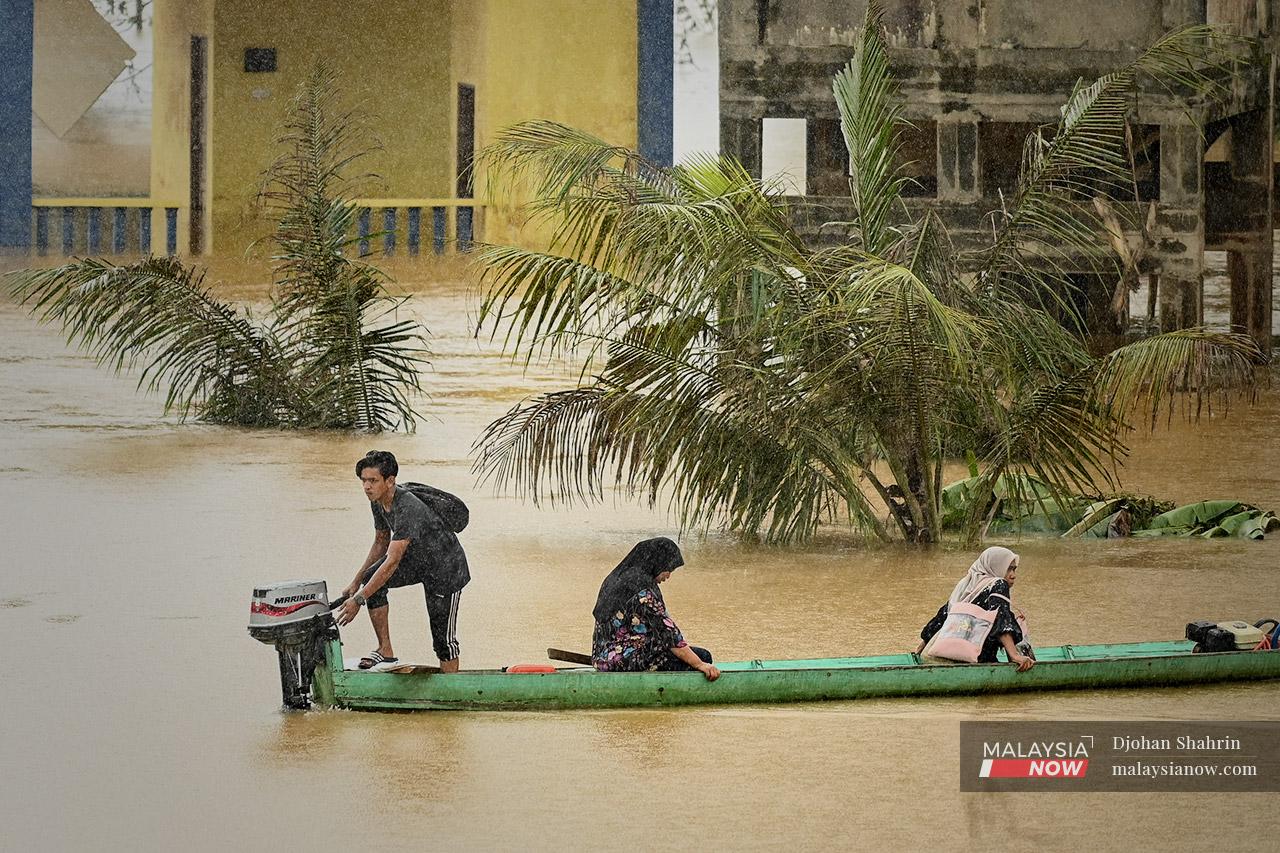 A teenager helps villagers evacuate by boat from their homes in Kampung Binjai, Kuala Lipis in Pahang. Pahang was one of several states to be hit by floods early this year due to heavy monsoon rain which fell continuously for several days.