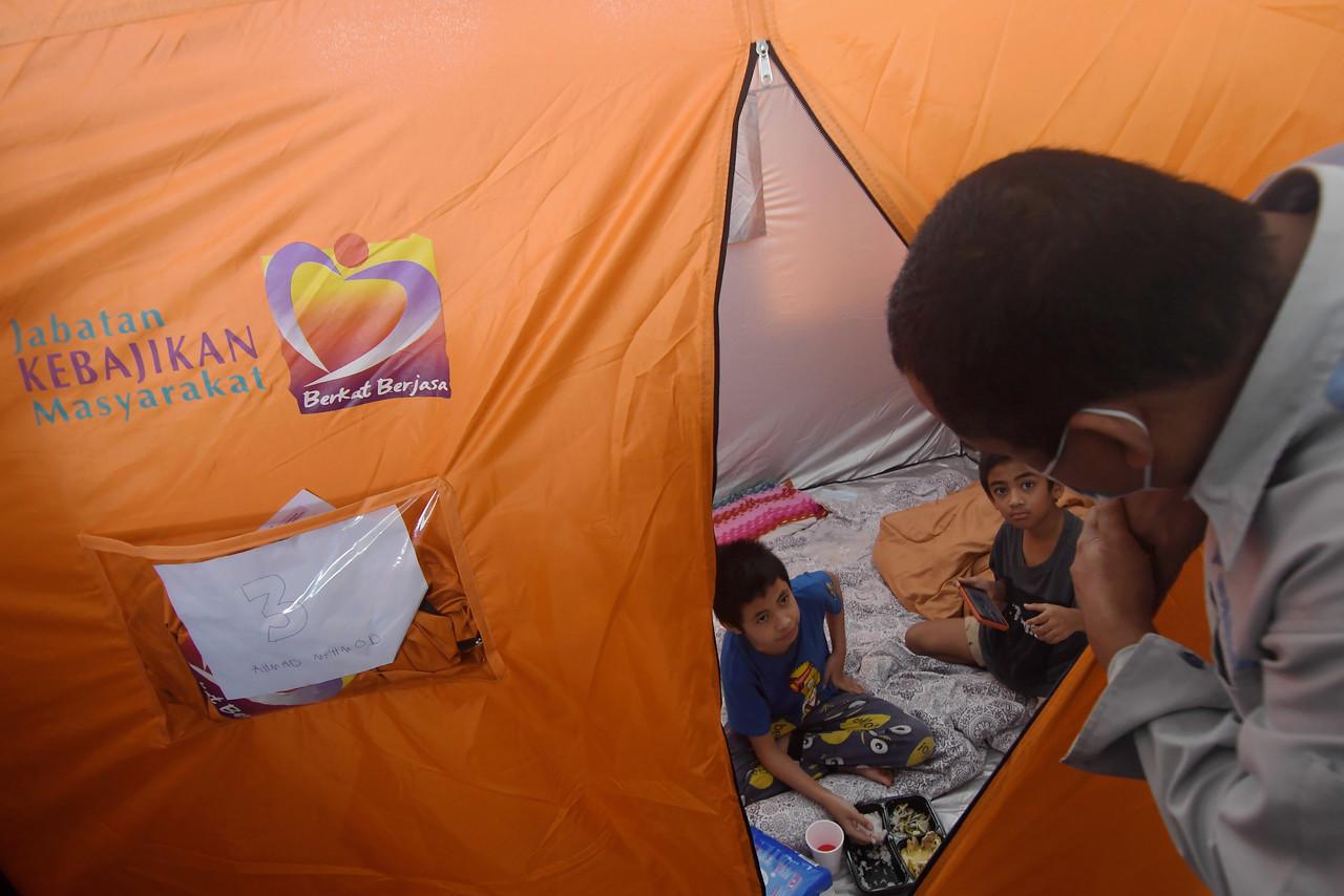Children sit in a tent at a temporary relief centre in Balai Raya Kampung Sungai Nangka, Banting, where they were taken after their home was hit by floods. Photo: Bernama