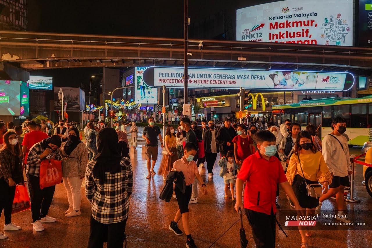 Pedestrians cross a junction in the Bukit Bintang shopping district in Kuala Lumpur.