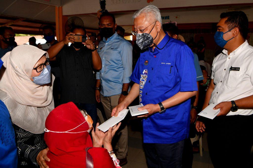 Perdana Menteri Ismail Sabri Yaakob memberikan bantuan derma kepada mangsa banjir di pusat pemindahan sementara Alor Gajah, Melaka. Gambar: Bernama