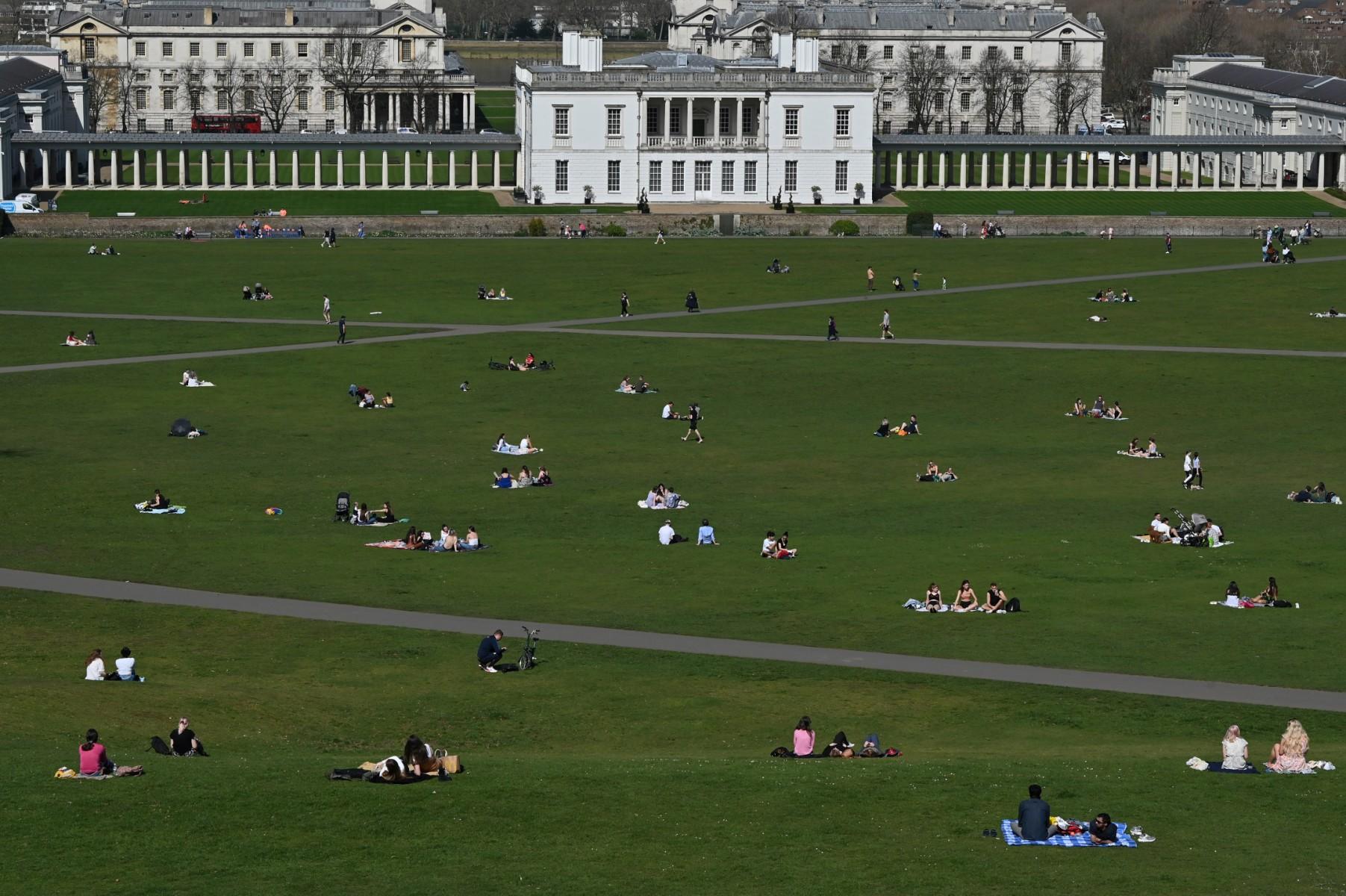 People enjoy the sunshine in Greenwich Park, southeast London on March 30, 2021, as England's third Covid-19 lockdown restrictions ease, allowing groups of up to six people to meet outside. Photo: AFP