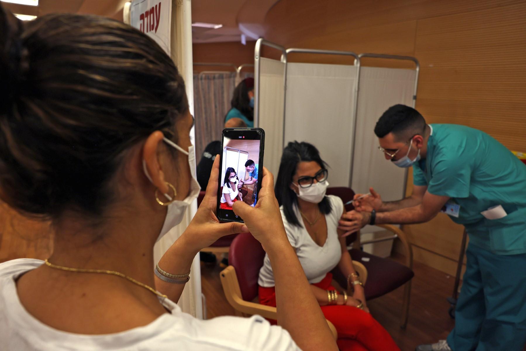 Israeli medics administer a third booster jab of the Covid vaccine to members of medical teams, at the Hadassah Ein Kerem Hospital in Jerusalem, on Aug 15, 2021. Photo: AFP