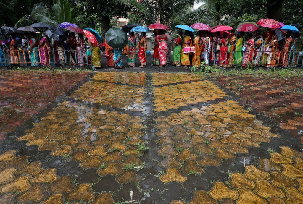 Women hold umbrellas as they wait in the rain to receive a shot of Covid-19 vaccine at a centre in Kolkata, India, in this Aug 31, 2021 file photo. India has had more than 35 million Covid-19 cases, the second highest tally after the US. Photo: Reuters