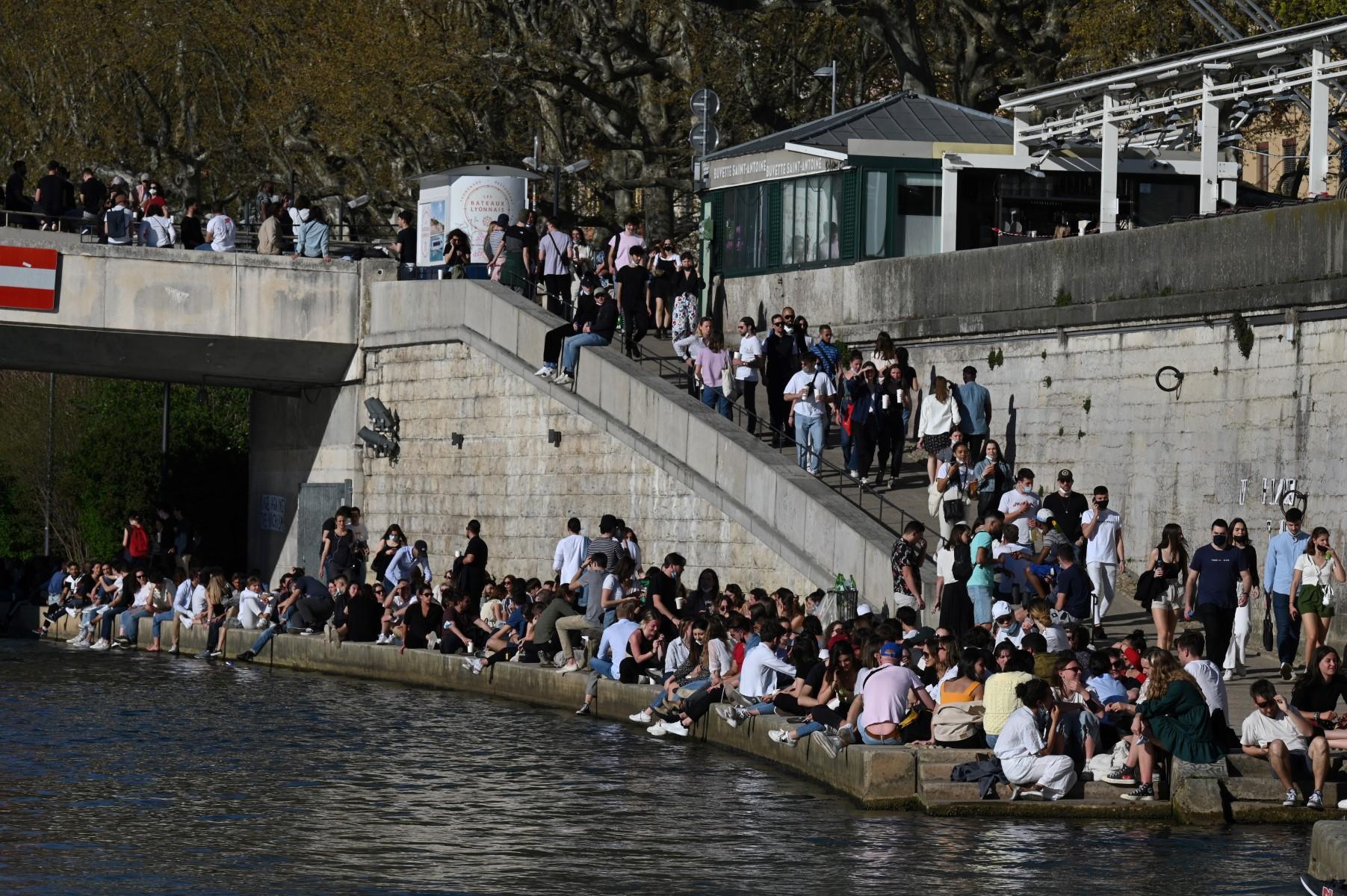 People gather on the Saone river banks in Lyon on March 31, 2021, before the start of the daily curfew aimed at curbing the spread of the Covid-19. Photo: AFP