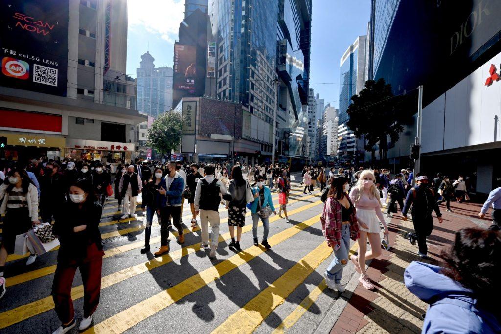 Pedestrians cross a busy intersection in Causeway Bay in Hong Kong on Jan 4. The government upped Covid restrictions this week, after a small outbreak of the Omicron variant was traced to a flight crew member. Photo: AFP