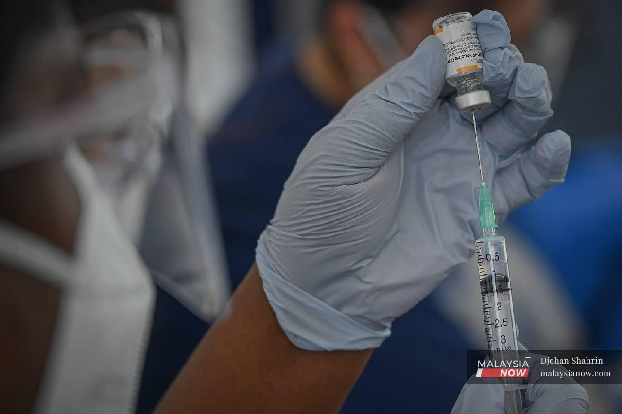 Petugas kesihatan Pusat Perubatan Ara Damansara memasukkan vaksin Sinovac ke dalam picagari di Menara Sime Darby Plantation, Subang.