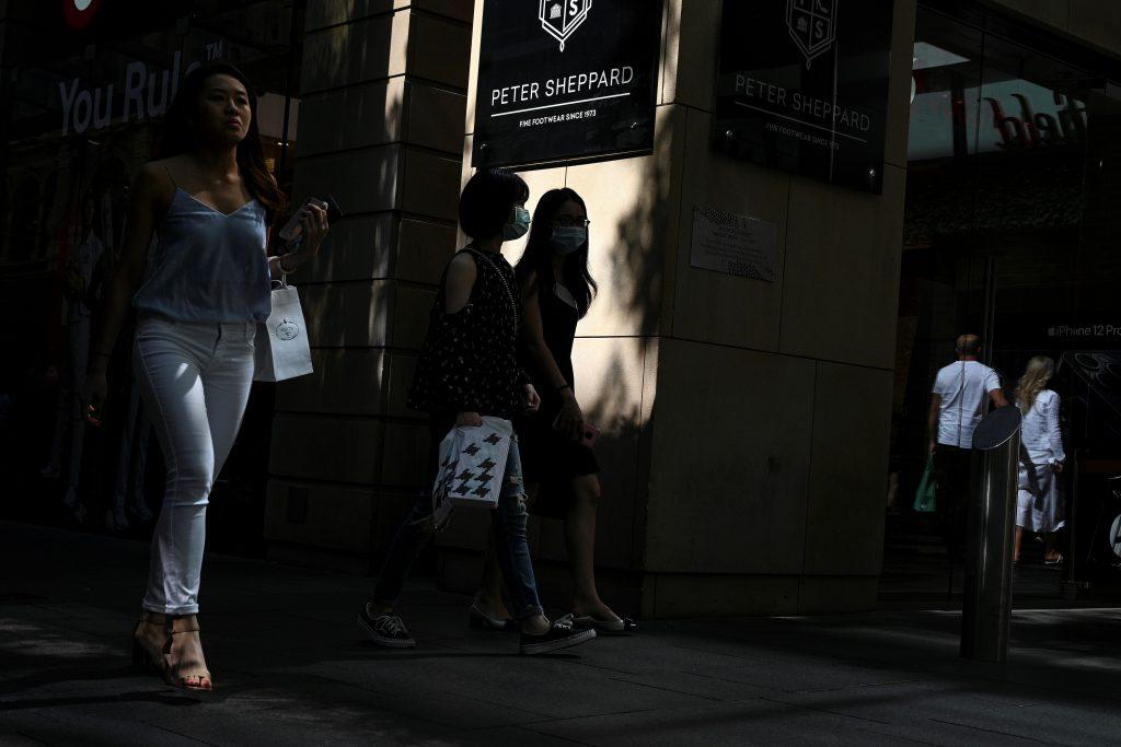 People wearing face masks due to the Covid-19 pandemic walk through a shopping arcade, usually packed with tourists, in the central business district of Sydney on Dec 24, 2020 file picture. Photo: AFP