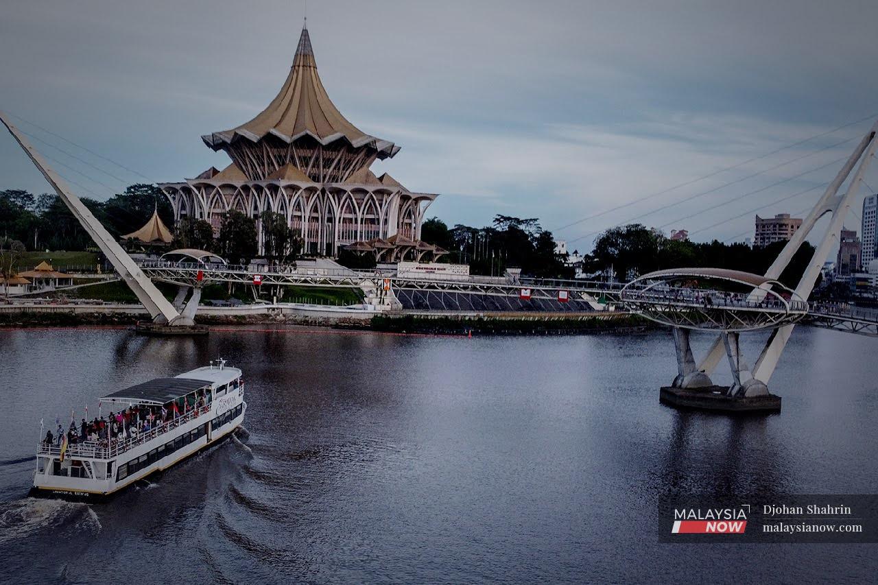 A river boat carries passengers across Sungai Sarawak, near the state legislative assembly building and the Darul Hana bridge at the Waterfront area in Kuching.