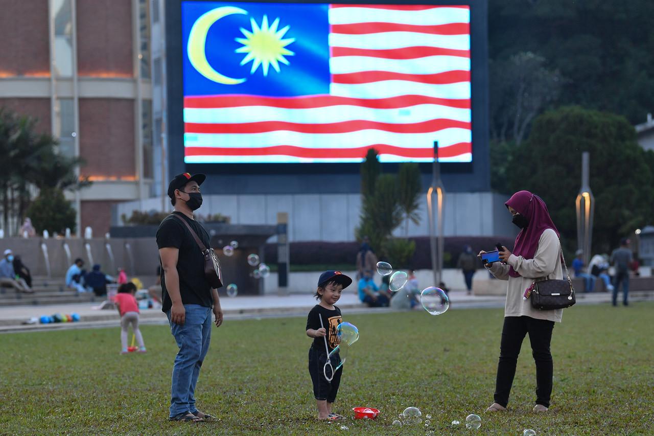 A family plays with bubbles over the weekend at Dataran Merdeka in Kuala Lumpur. Photo: Bernama