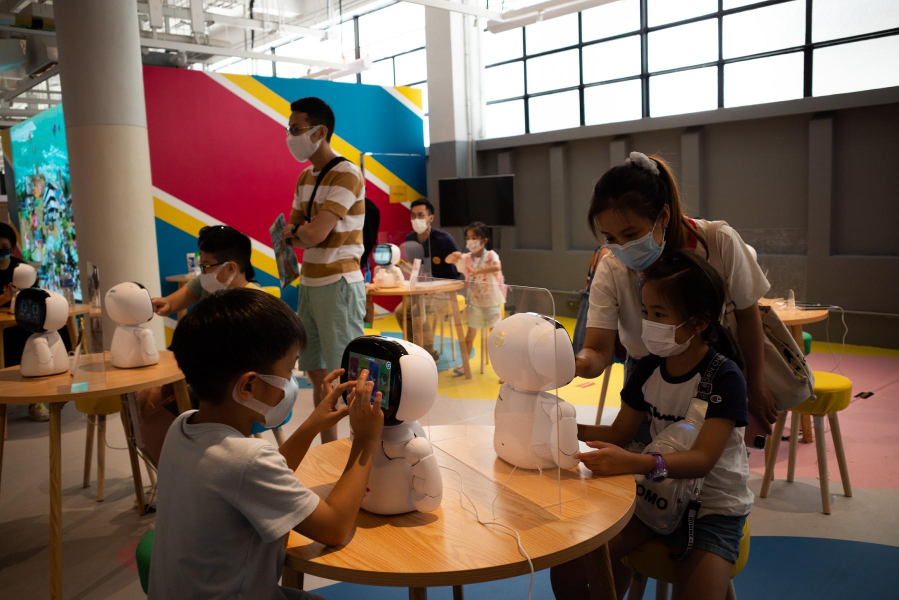 Children play with a robotic machine at the reopened Central Market after its makeover, in Hong Kong on August 26, 2021. Photo: AFP